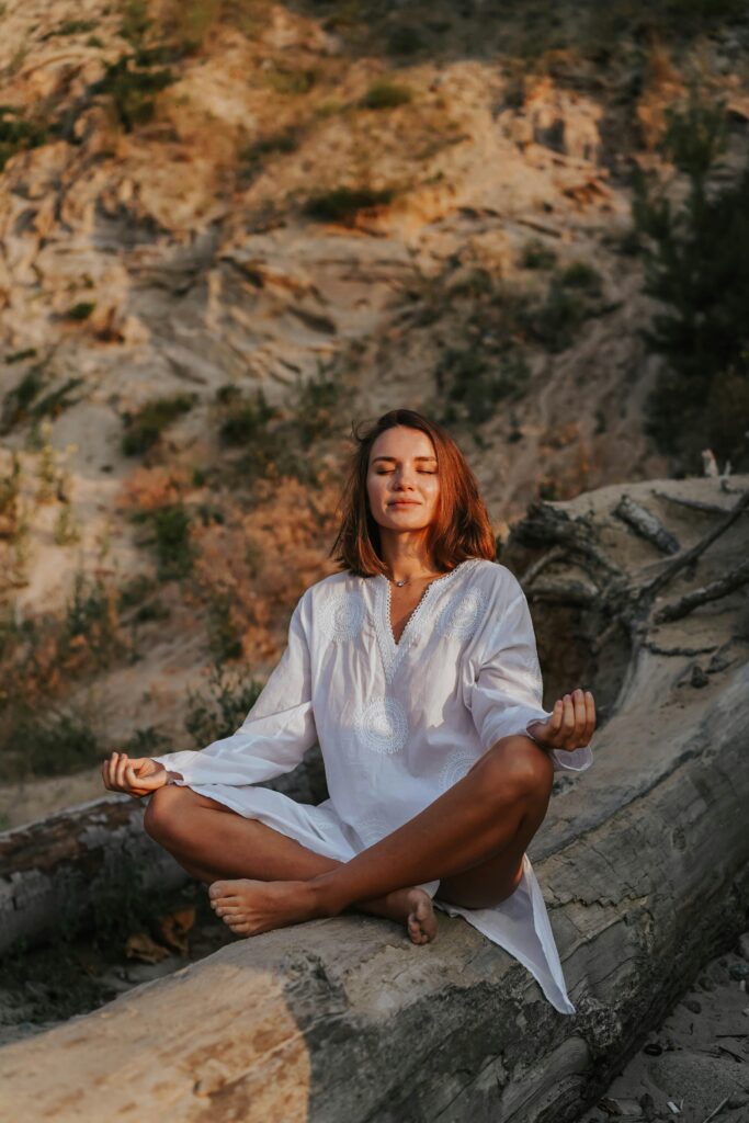 Uma pessoa meditando em um ambiente tranquilo, cercada pela natureza, transmitindo calma e serenidade